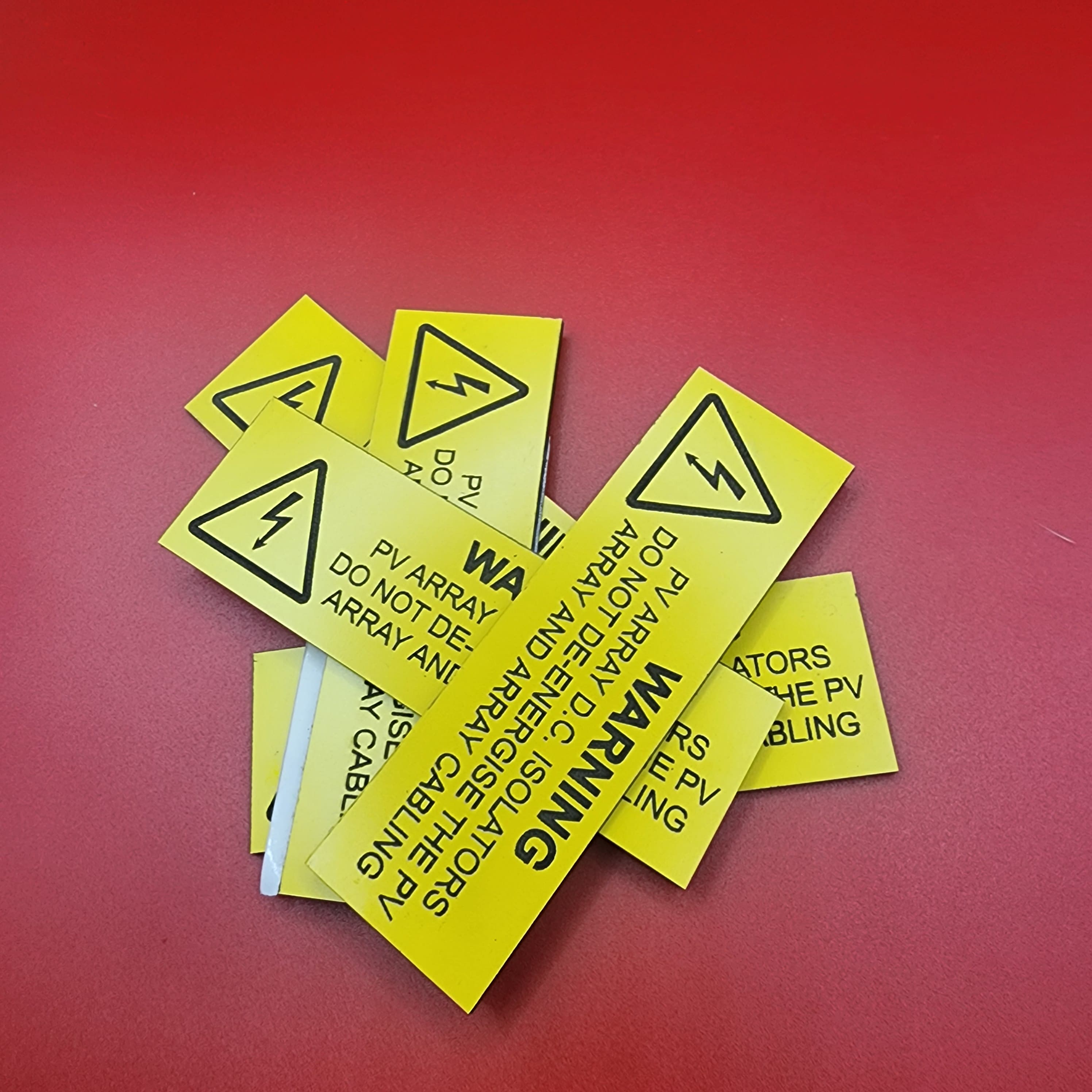 Batch of yellow PV array warning labels engraved in traffolyte